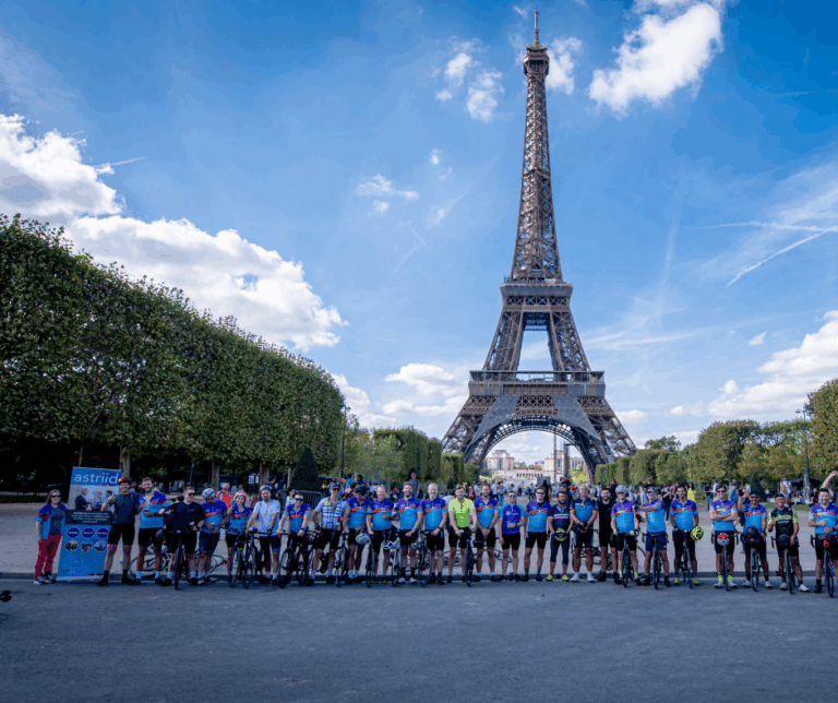 picture of riders from the London to Paris cycle for Astriid stood in front of the Eiffel Tower
