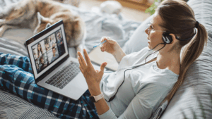 A woman on a virtual meeting while in pyjamas and sat in her bed, to symbolise disability and work.